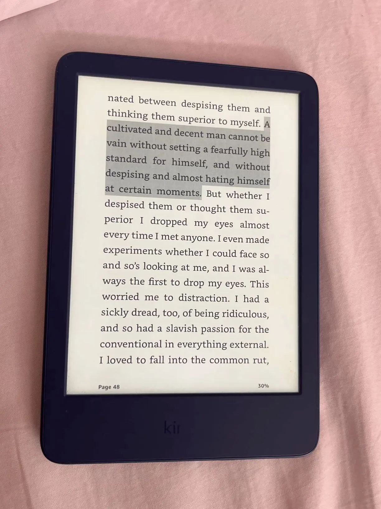 a kindle sitting on top of a pink sheet