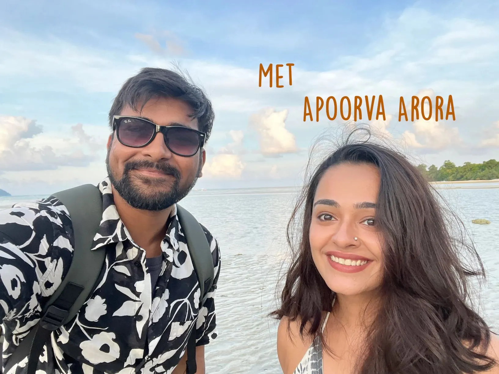 a man and woman taking a selfie in front of the ocean with an island in the background