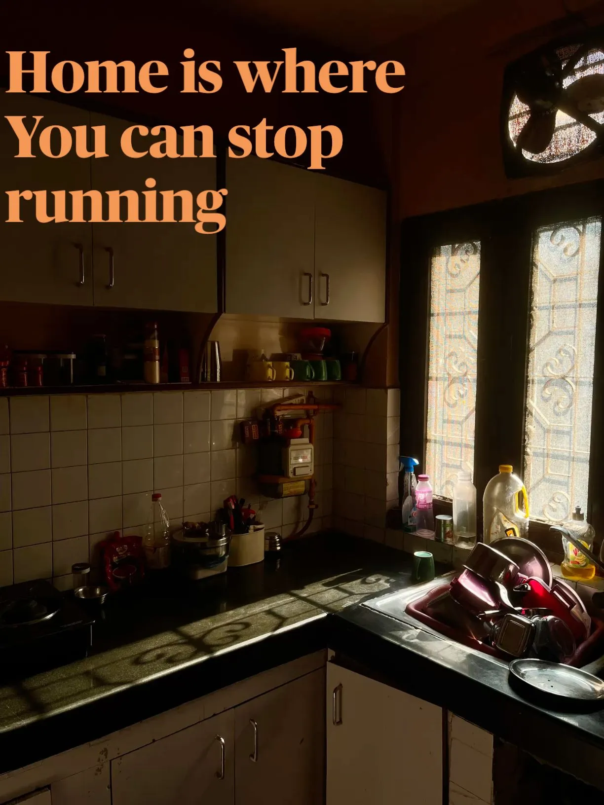 a kitchen with a sink, stove top and window in the background that says home is where you can stop running
