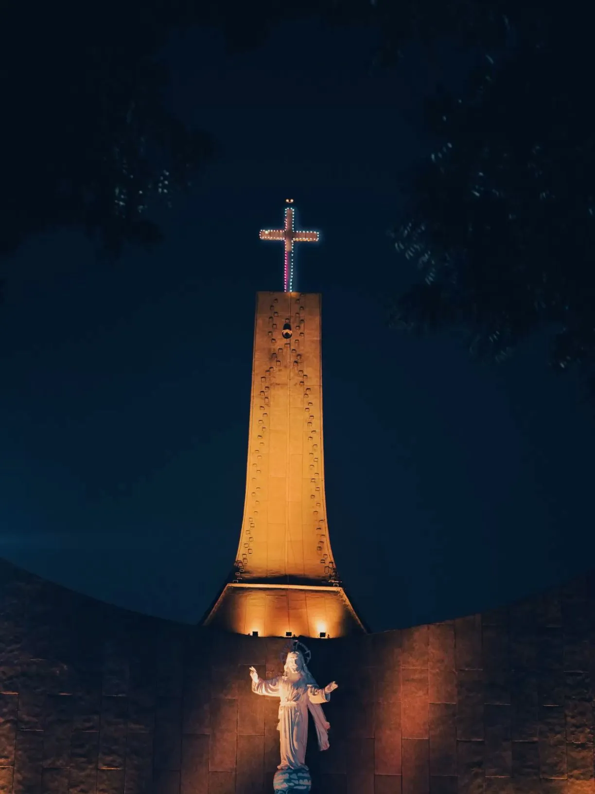 a lit up cross on top of a building