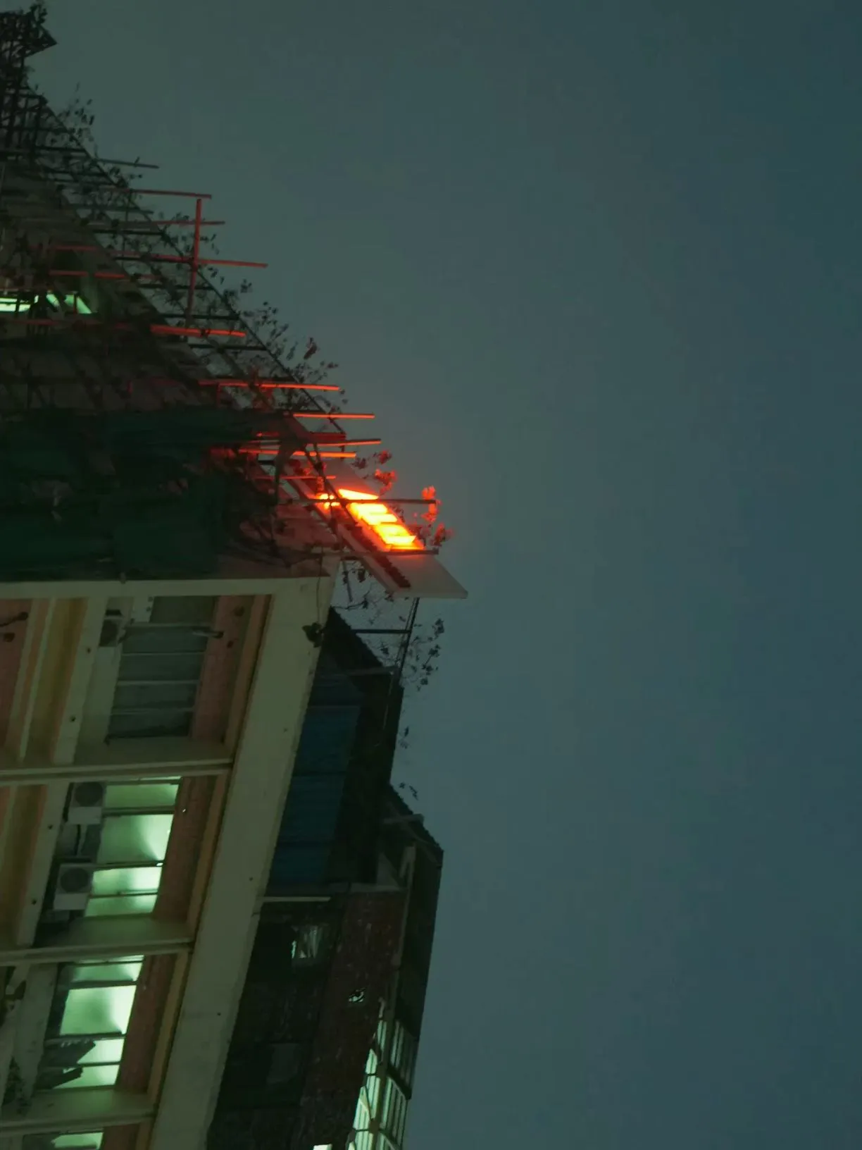 the top of a tall building with scaffolding on it's sides at night