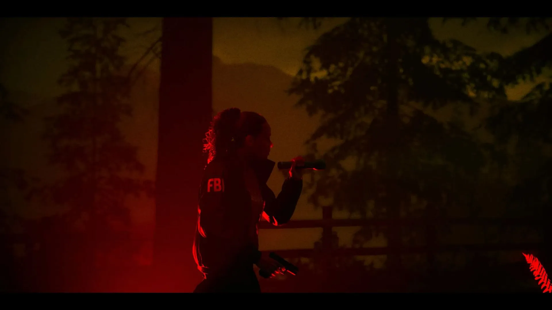 a woman standing in the dark holding a cell phone to her ear