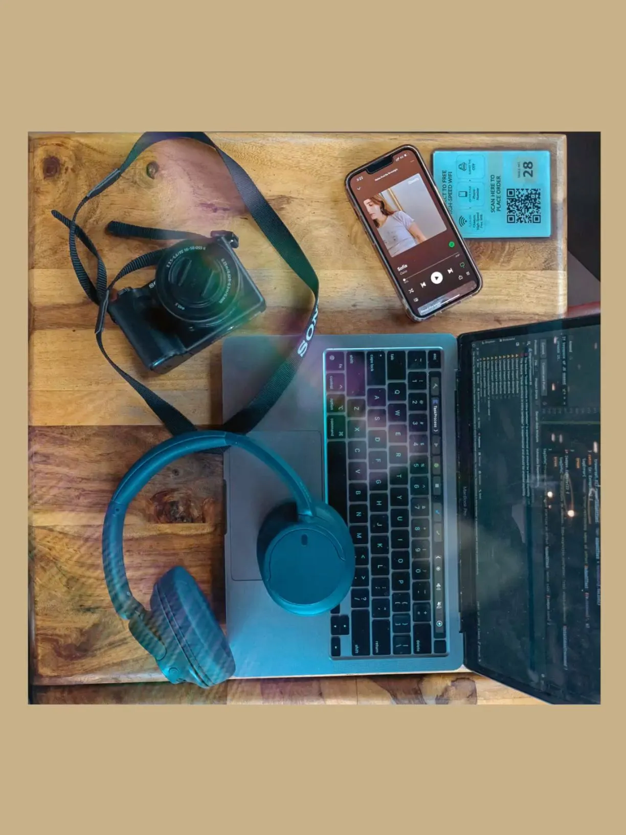 a laptop computer sitting on top of a wooden table next to headphones and other items