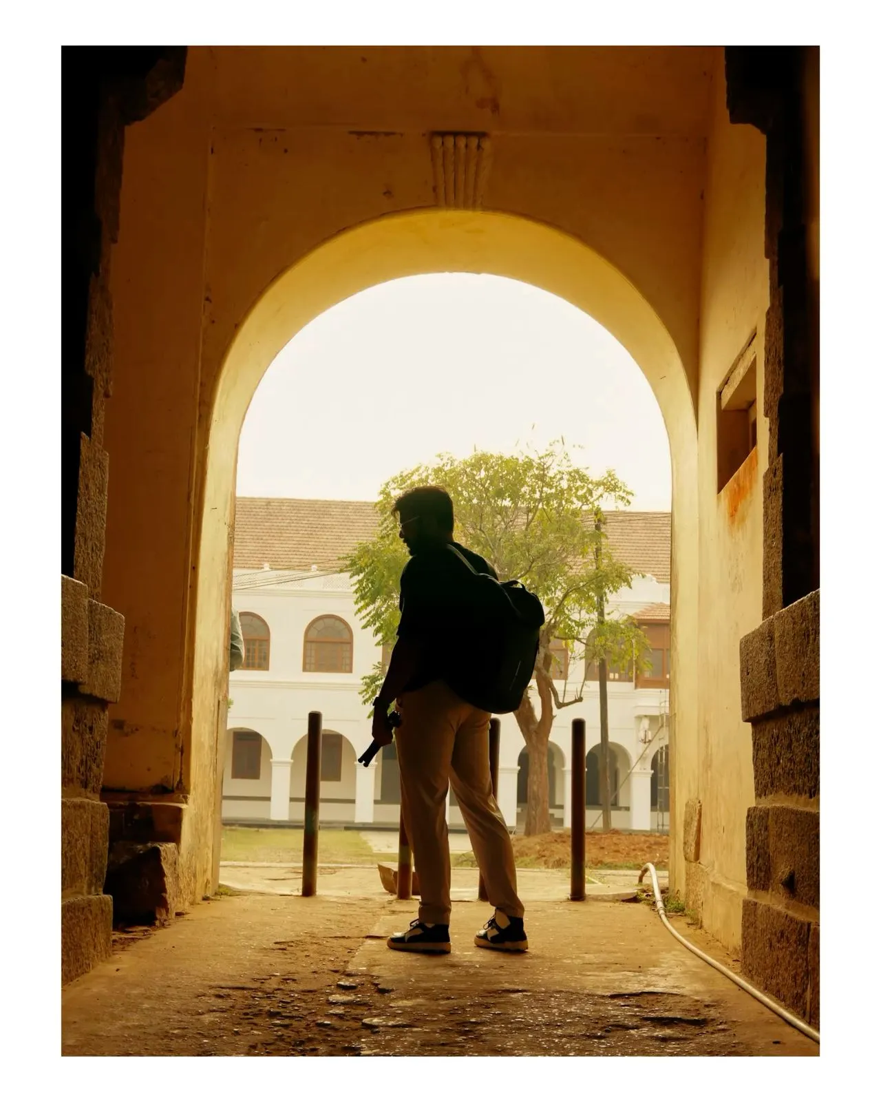 a person with a backpack is standing in an archway