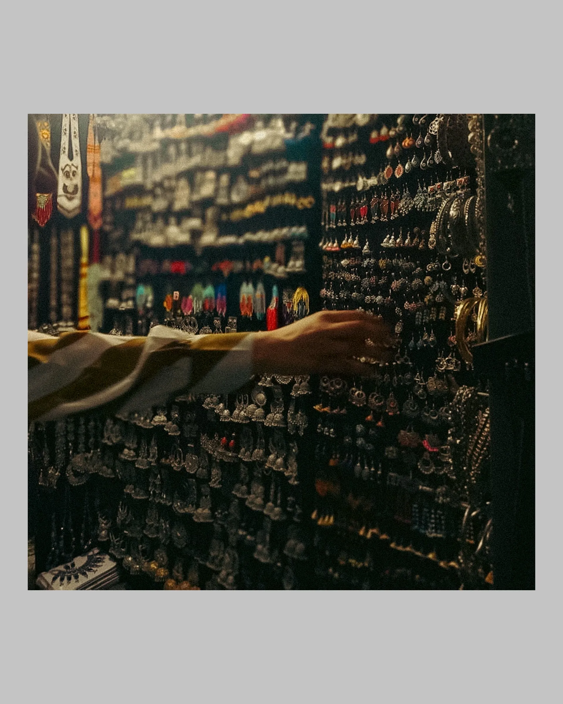 there is a man that is looking at many items on the wall in this store
