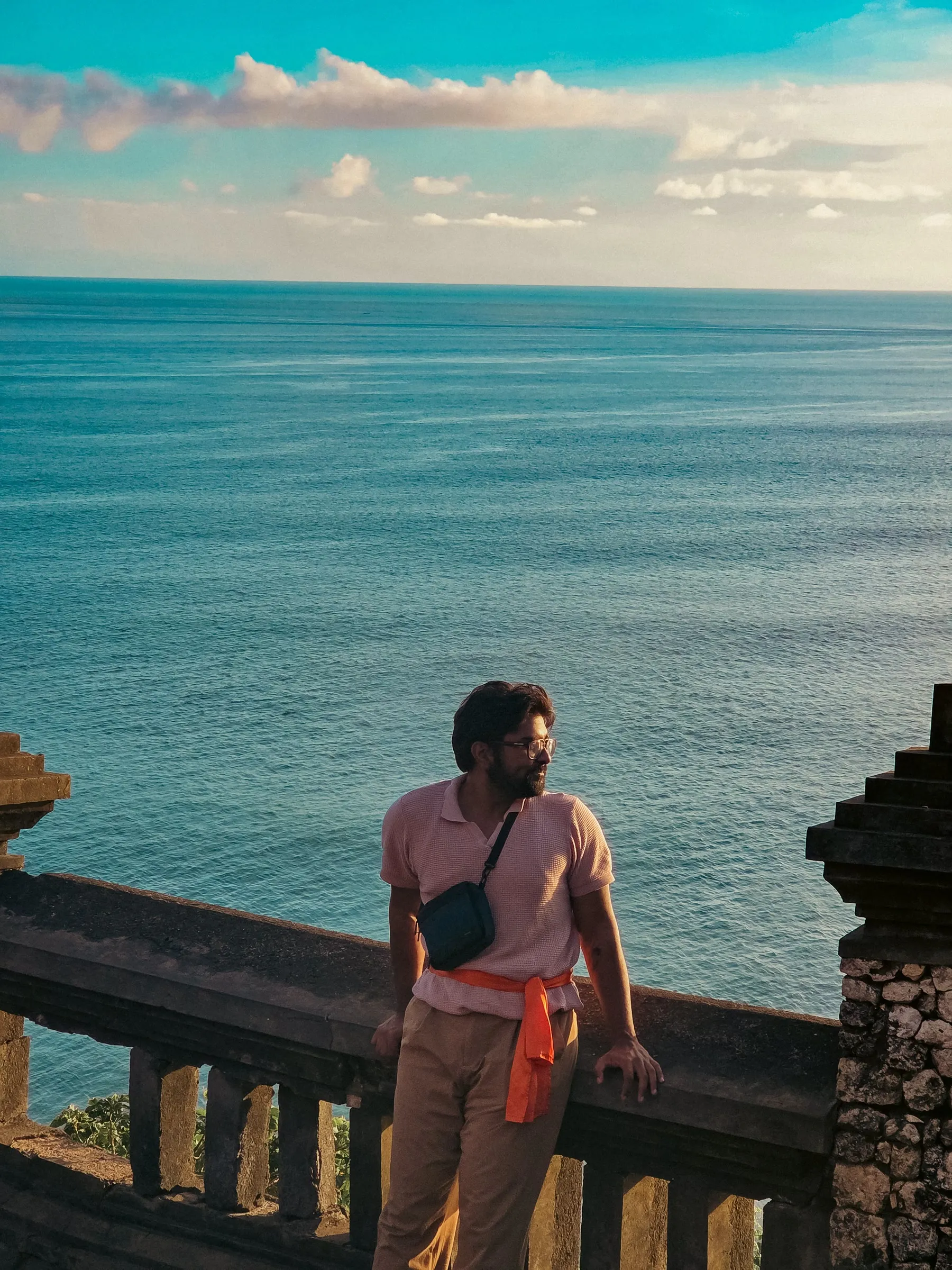 a man is standing on a balcony overlooking the ocean