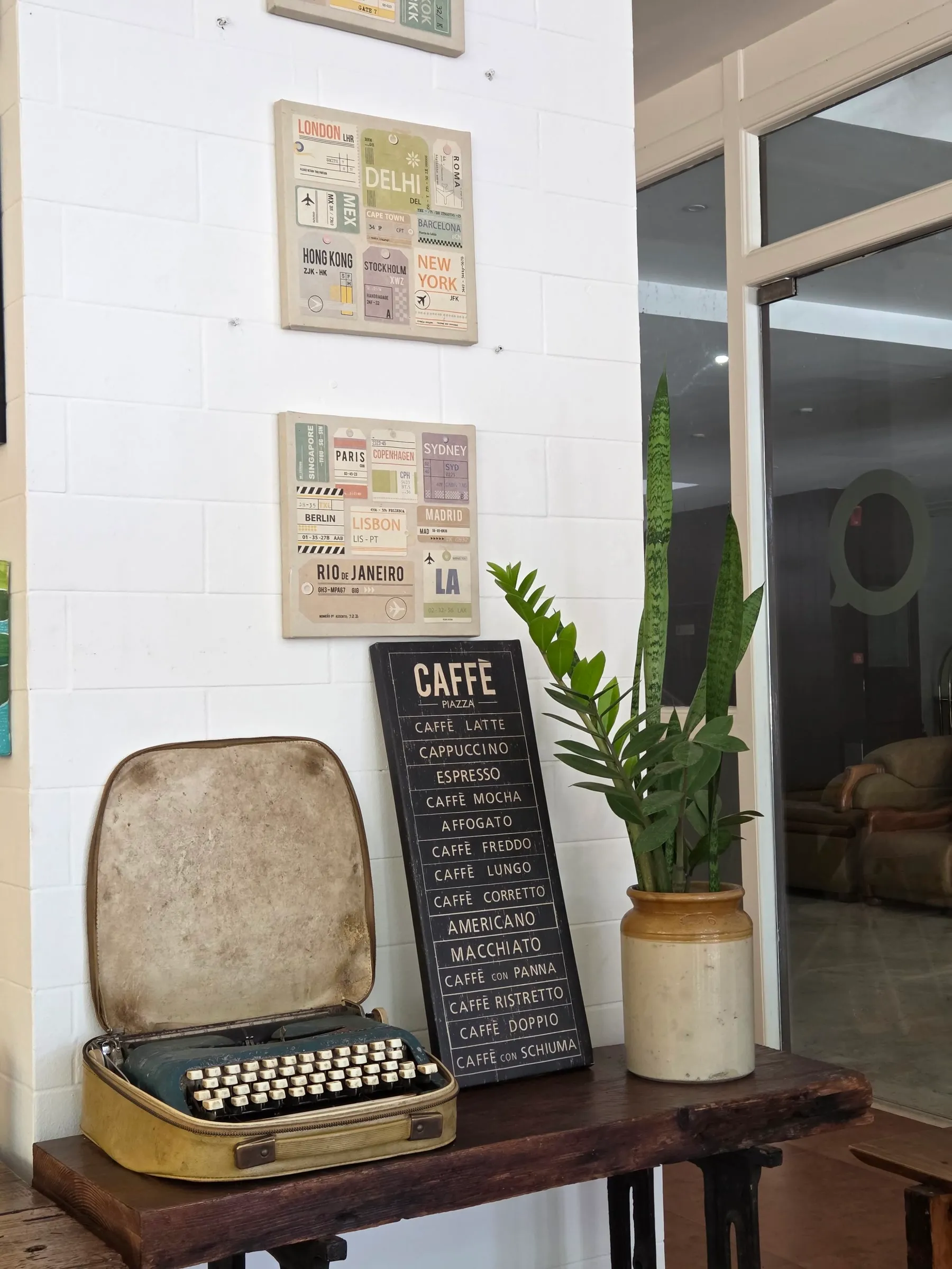 an old typewriter sitting on top of a wooden table next to a potted plant